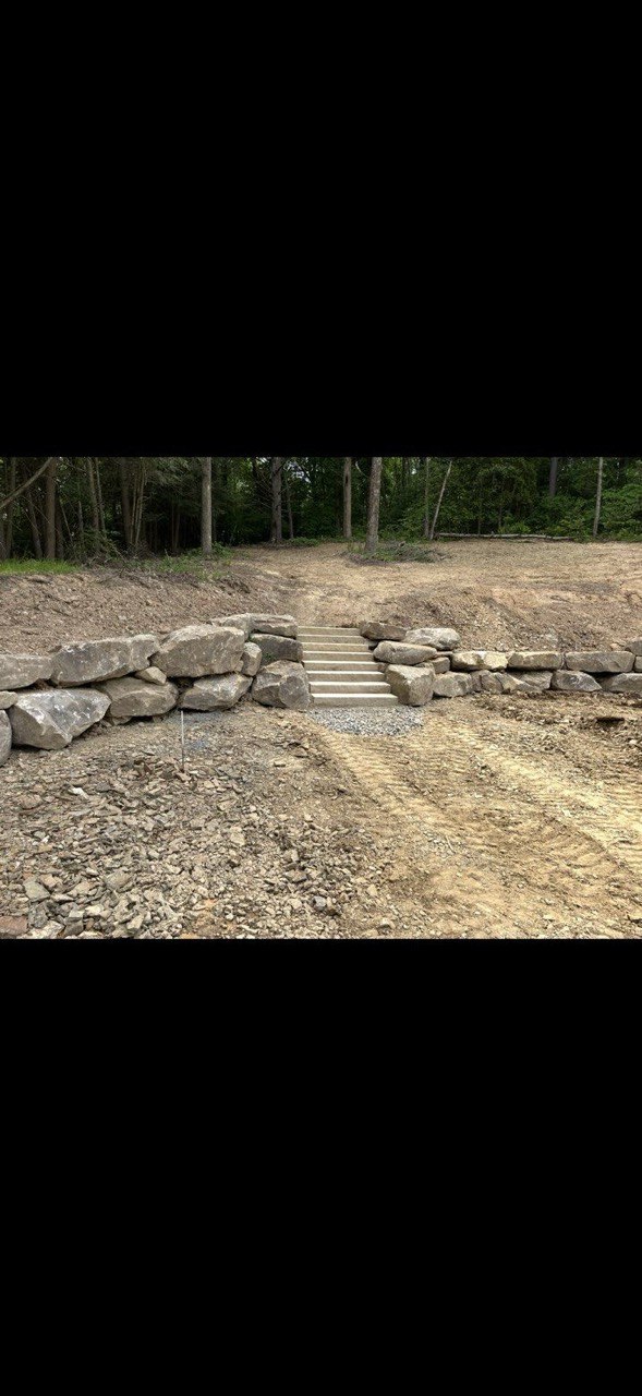 Boulder retaining wall with concrete steps